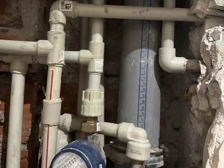 Wodomierz i stare rury w rozkutej ścianie — DobryHydraulik Szczecin